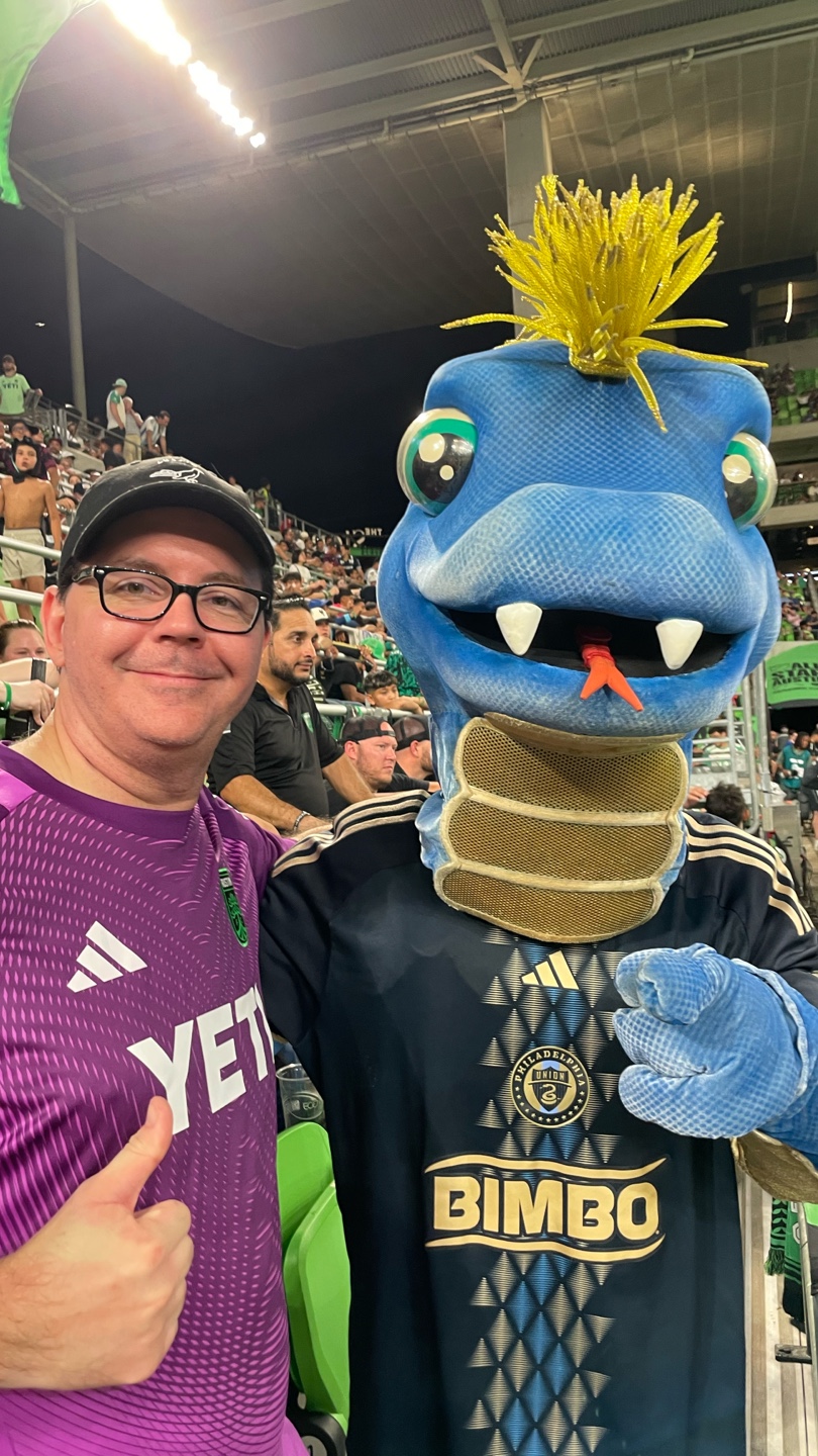 A man and the Philadelphia Union Phang mascots posing.