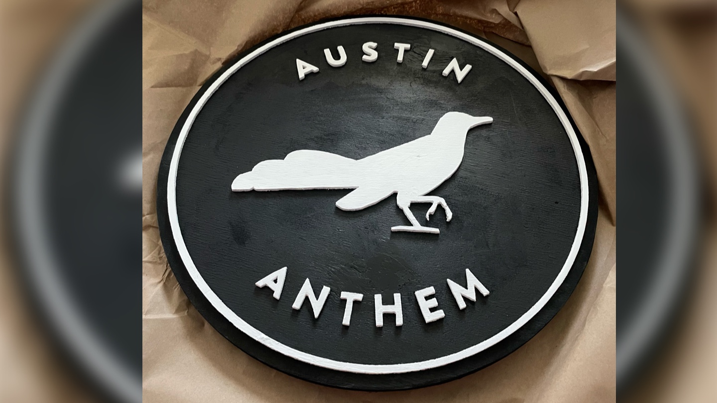 A wooden sign of the Austin Anthem logo.