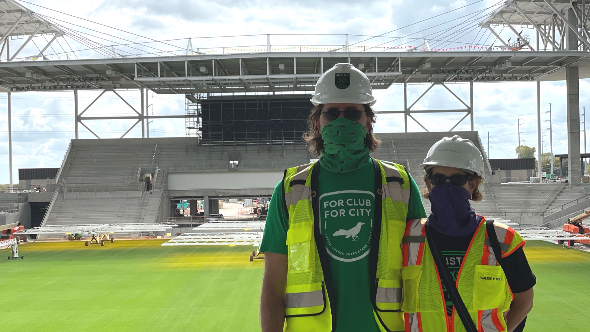 /content/A couple in hard hats in a stadium under construction.